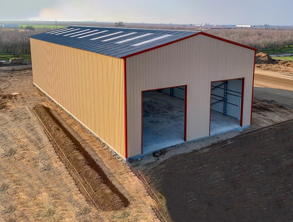Aerial view of tan steel workshop with dark roof and red trim