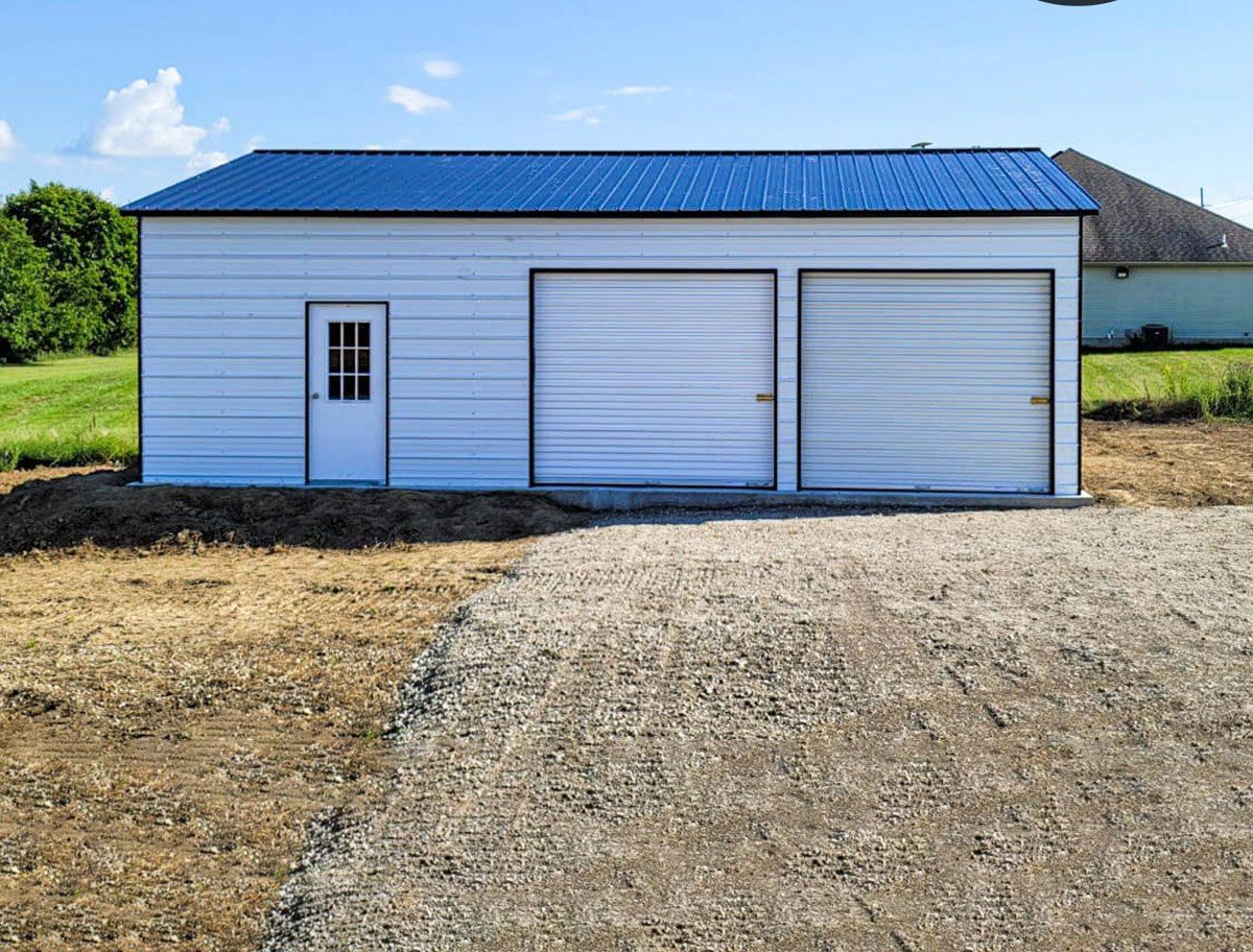 Side view of white steel garage with blue roof and two roll-up doors