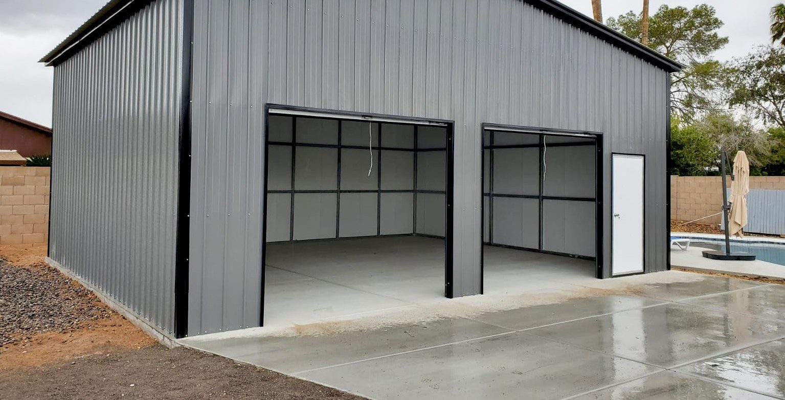 Gray steel garage with open bays beside a backyard pool