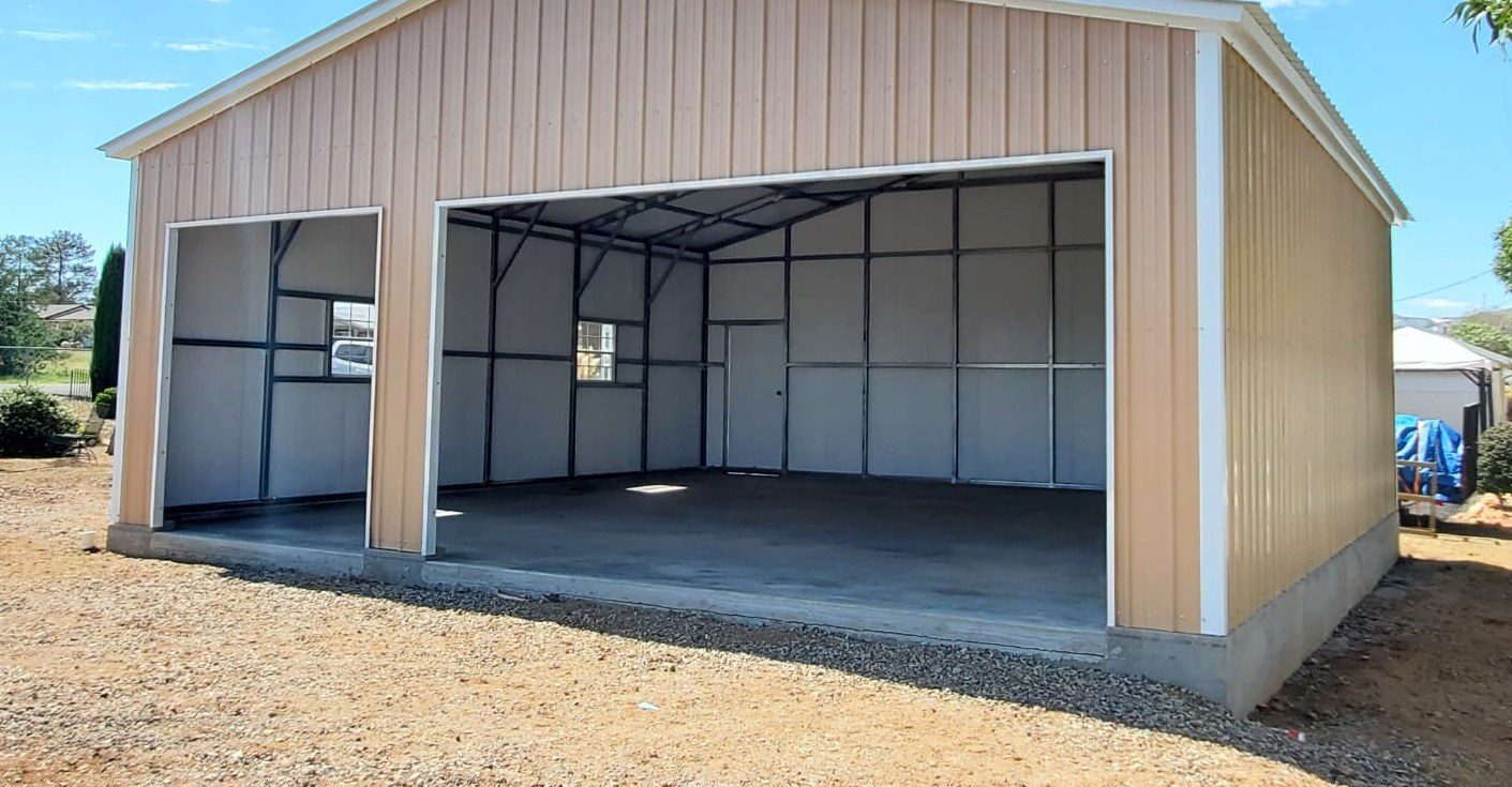 Tan steel garage with wide open bays on concrete slab