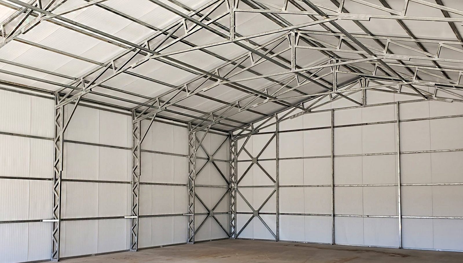 Clear-span steel building interior showing tubular frame and trusses