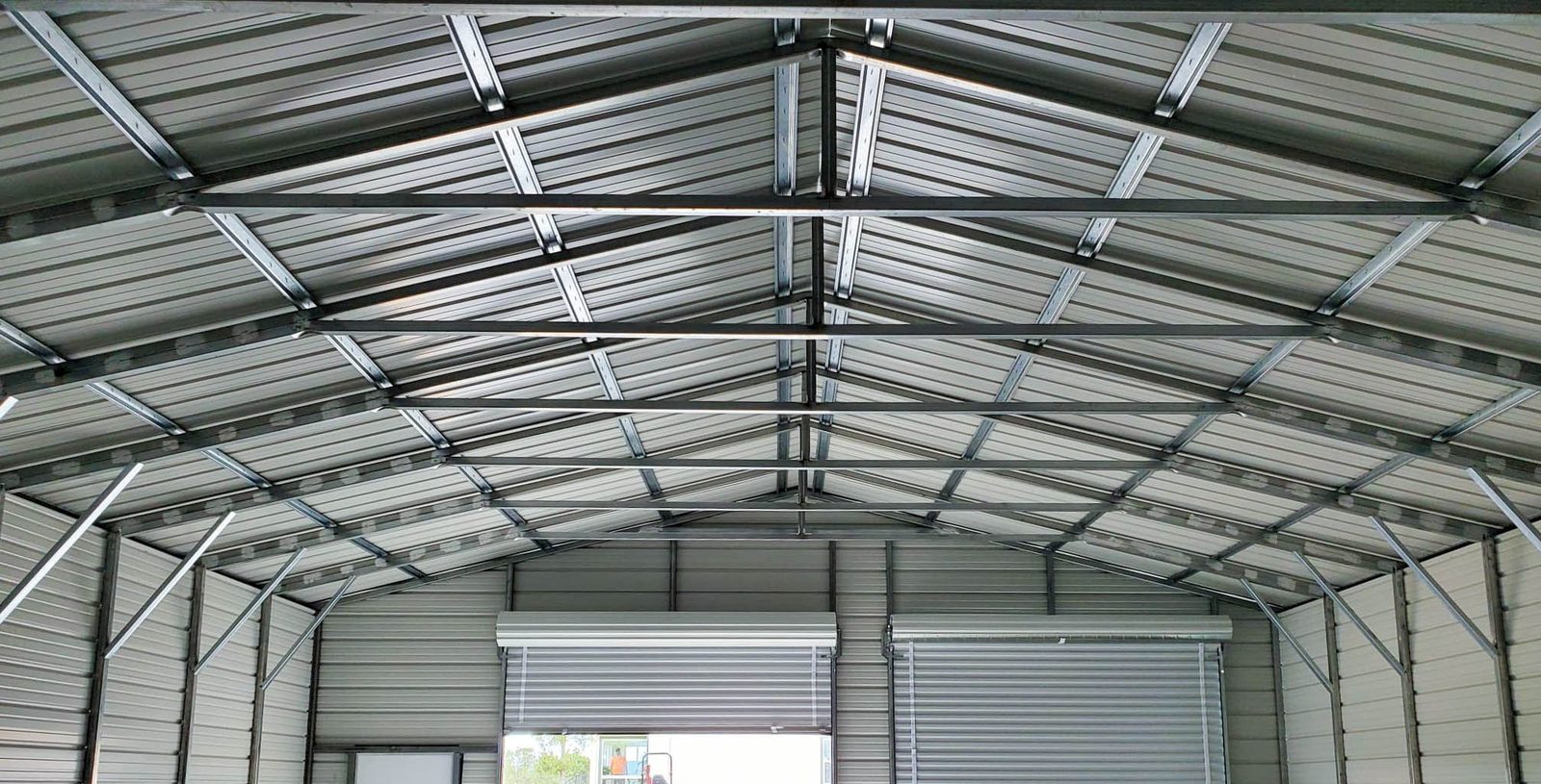 Steel workshop interior with open roll-up bay and galvanized framing
