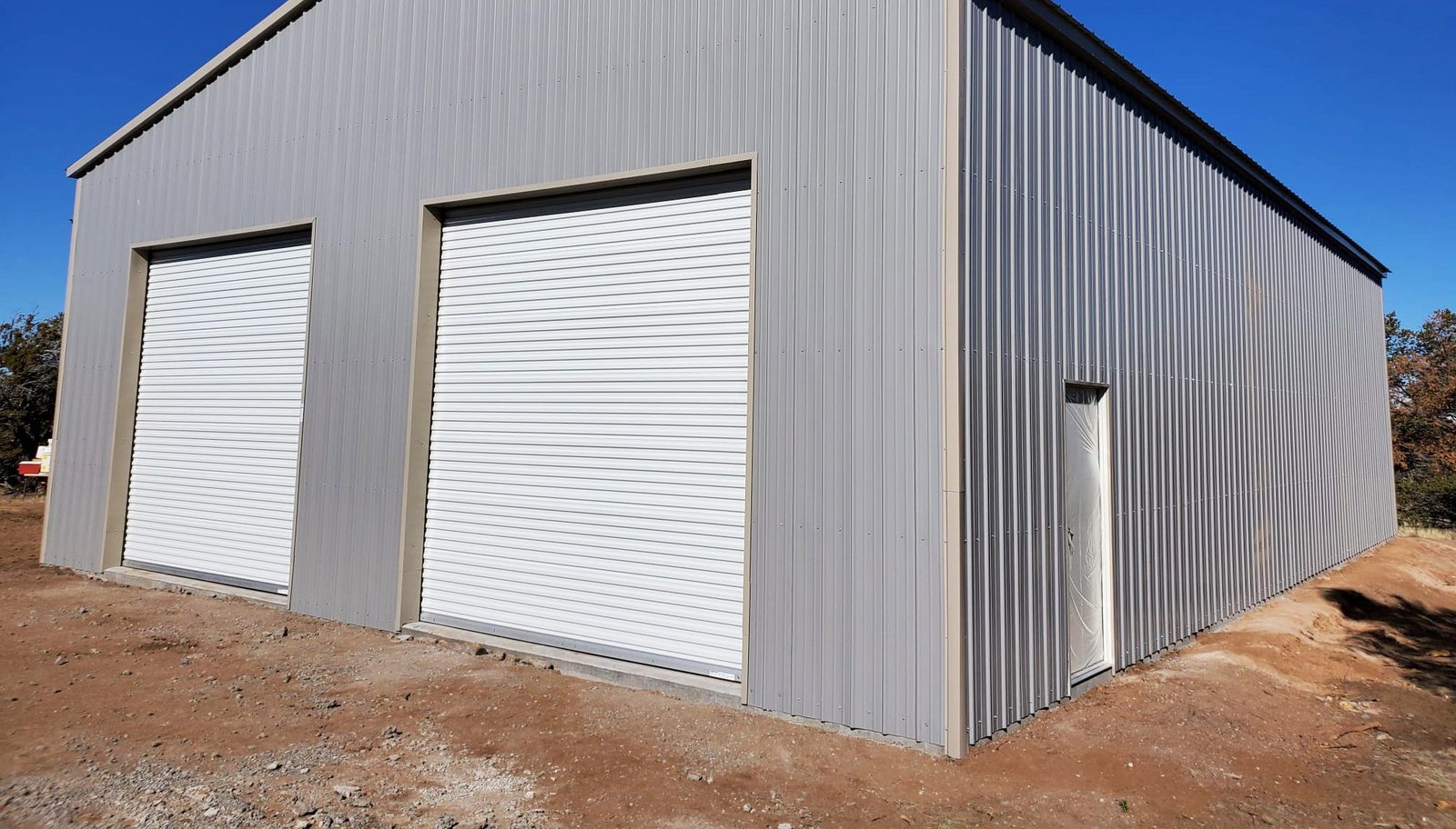 Silver steel workshop with two large roll-up doors